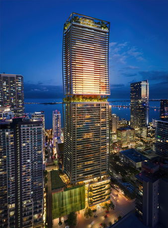 Front view of a modern skyscraper with illuminated facade at night.