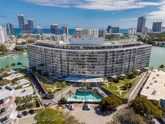 View of a large multi-story building with ocean and cityscape in the background.