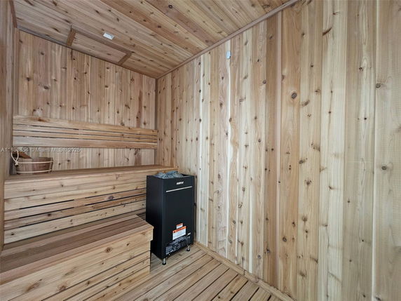 Interior view of a wooden sauna room with benches and a heater.