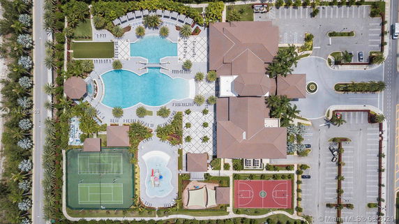 Aerial view of a large recreational area with swimming pools, tennis courts, and parking lots.