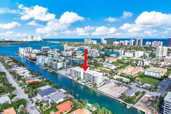 Aerial view of a coastal cityscape with waterways and high-rise buildings.