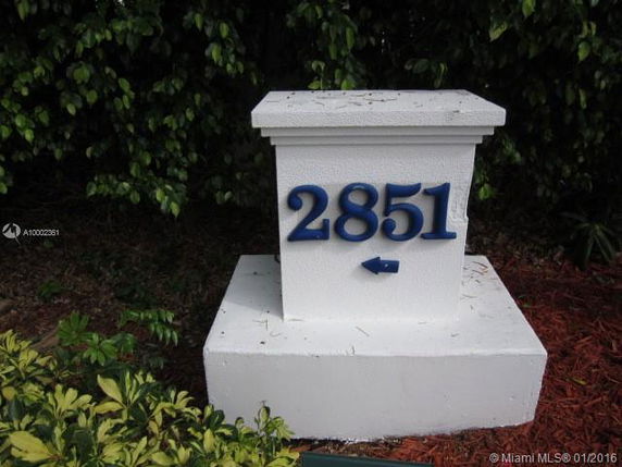 White outdoor post with the number 2851 and an arrow pointing left.