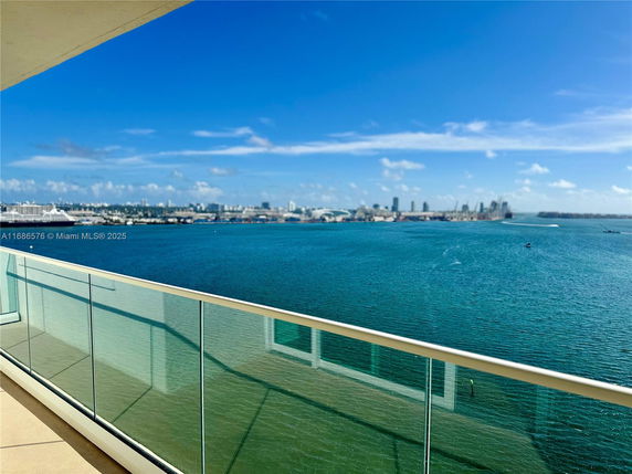 Panoramic view from a balcony overlooking water and city skyline.