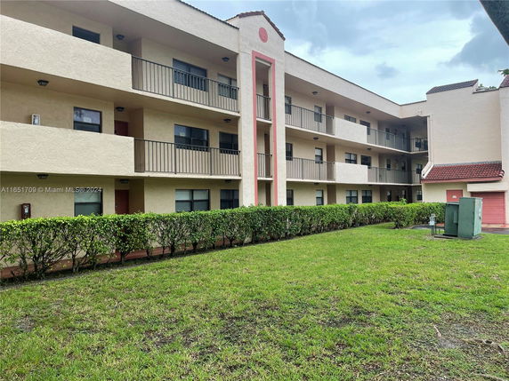 Front view of a three-story apartment building with balconies.