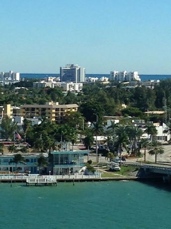 Panoramic view of urban skyline with buildings and ocean in the background.
