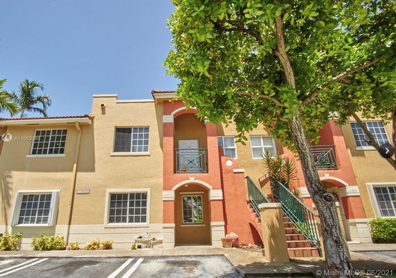 Front view of a two-story residential building with stairs.