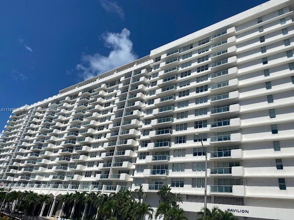 Front view of a multi-story residential building with numerous balconies.