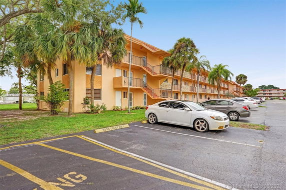 Front view of a three-story building with outdoor parking area.