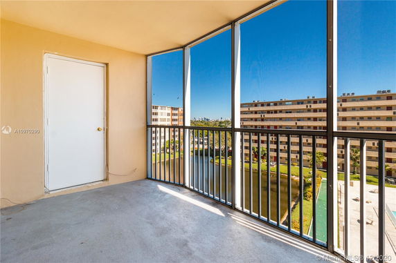View from a balcony with railing overlooking multiple apartment buildings and a body of water.
