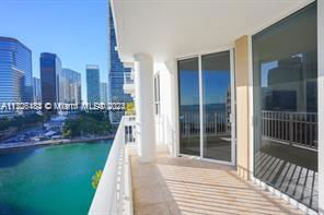 Balcony view from a high-rise building overlooking a body of water and city skyline.