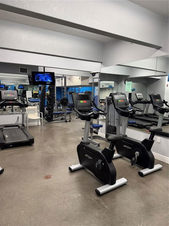 Indoor gym area with exercise equipment and mirrors.