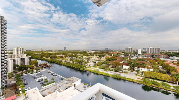 Wide angle view of cityscape with buildings and waterway.