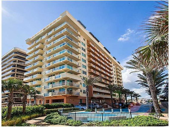 Front view of a multi-story apartment building with balconies.