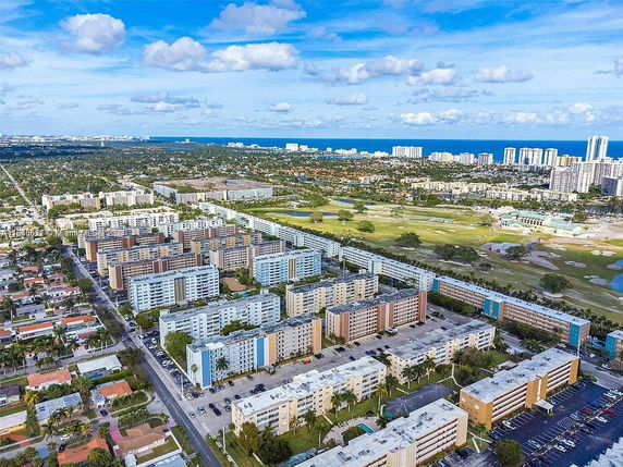 Aerial view of a residential area with multiple apartment buildings and a distant view of the coastline.