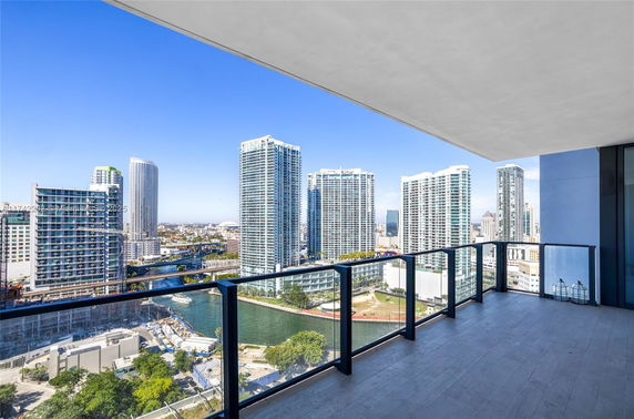 Panoramic view from a balcony overlooking high-rise buildings and a river.