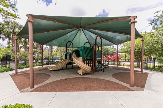A shaded playground with slides and climbing structures.