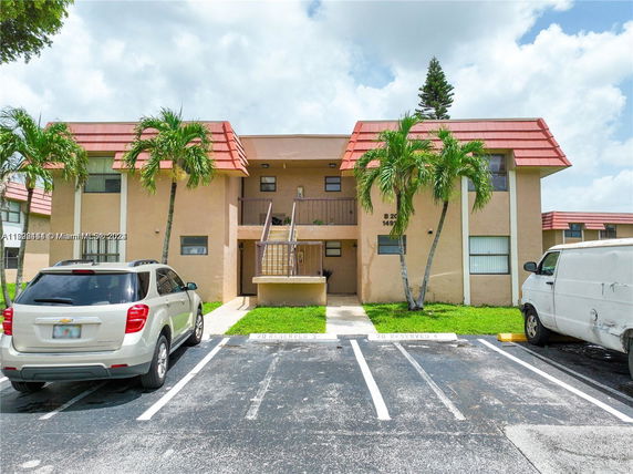 Front view of a two-story residential building with a central staircase and red-tiled roof.