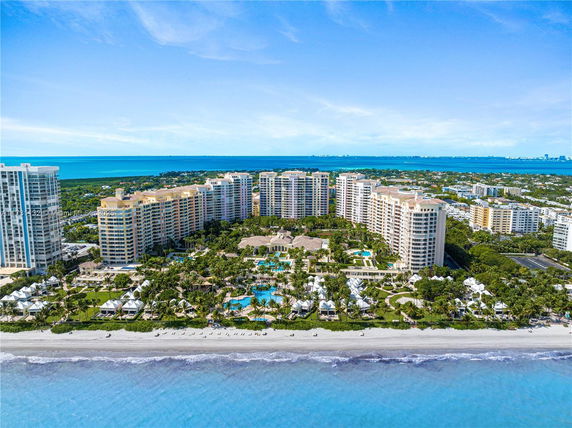 Elevated view of a beachfront resort with multiple high-rise buildings and swimming pools.