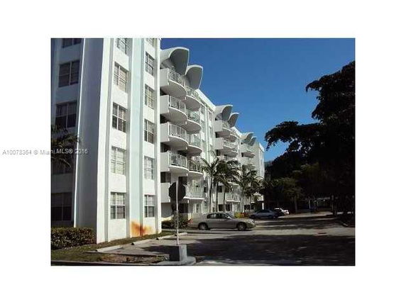 Front view of a multi-story apartment building with balconies.