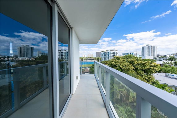 View from a balcony showing nearby buildings and greenery.