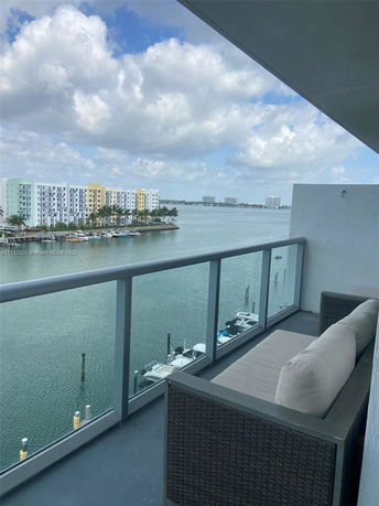 View of surrounding areas from a balcony overlooking water and buildings.