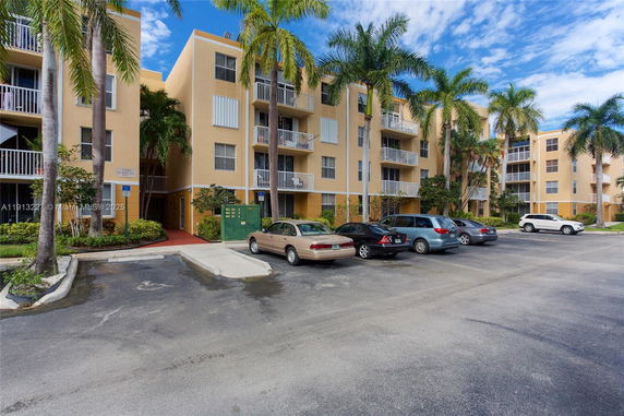 Front view of a four-story apartment building with balconies.