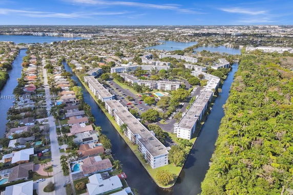 Aerial view of a residential area with numerous houses and water bodies.