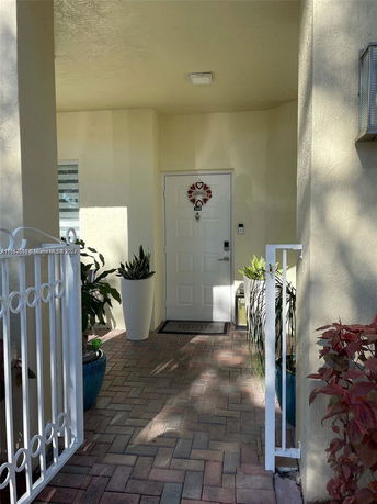 Entrance view of a house with a white door and plants.