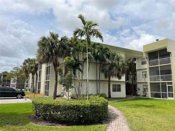 Front view of a multi-story residential building with balconies and a flat roof.