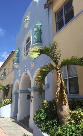 Front view of a two-story building with decorative wrought iron details and arched entrances.