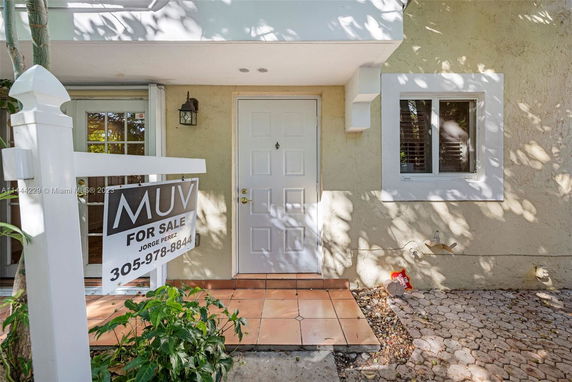 Front entry view of a house with a for sale sign.