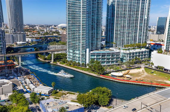 Aerial view of high-rise buildings near a river with a boat.