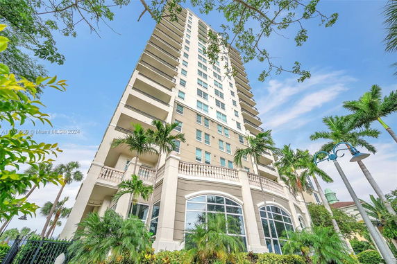 Front view of a tall residential building with multiple balconies.