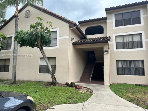 Front view of a two-story residential building with a staircase entrance.