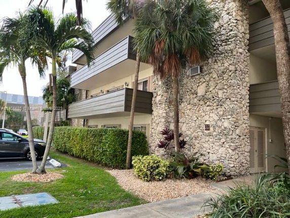 Front view of a multi-story building with stone exterior and balconies.