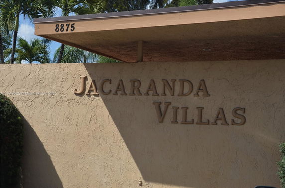 Front view of a building entrance with 'Jacaranda Villas' sign and an address number.