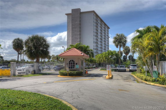 Front view of a high-rise residential building with a gated entrance.
