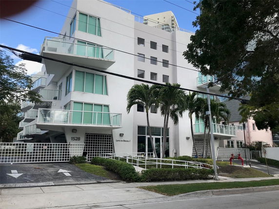 Front view of a multi-story building with balconies and glass railings.