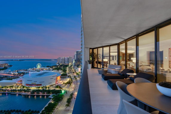Panoramic view from a high-rise balcony showing a city skyline and waterfront.
