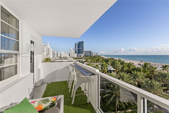 Balcony with a view of the ocean and beach from a modern building.