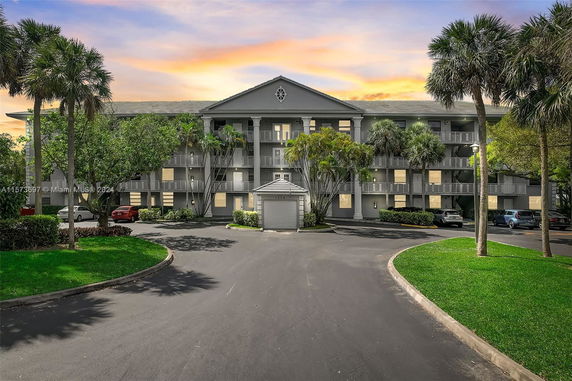 Front view of a three-story apartment building with balconies.