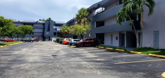 Outdoor parking area in front of a multi-story building.