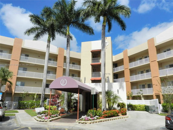Front view of a multi-story building with balconies and an entrance canopy.
