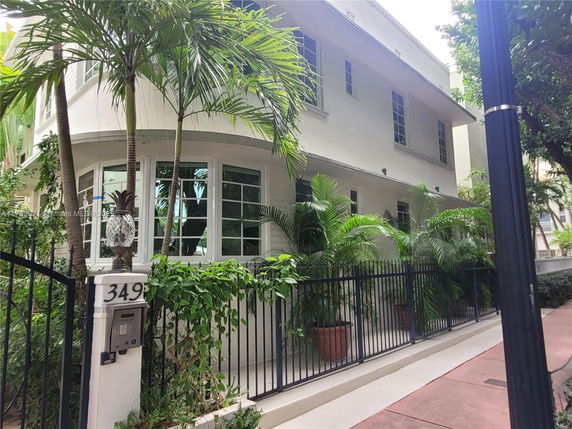 Front view of a two-story house with white exterior and large windows.