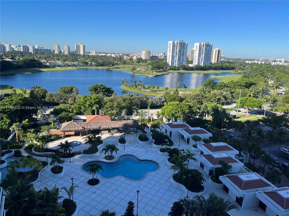 View of a lake with surrounding buildings and green landscape.
