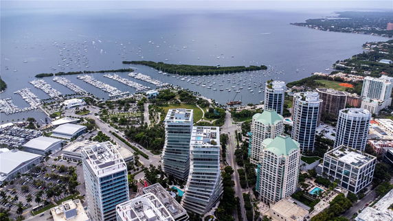 Aerial view of a coastal cityscape with high-rise buildings and a marina.