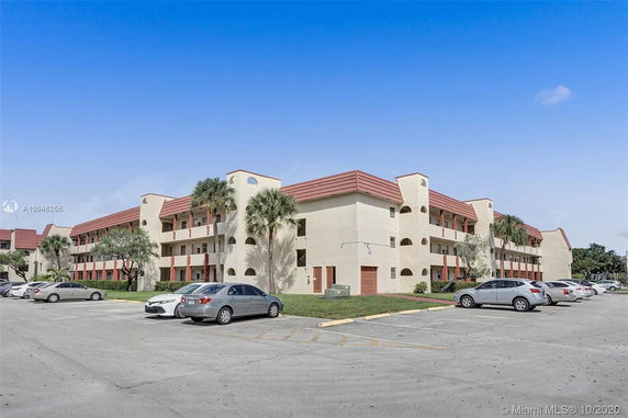 Front view of a multi-story apartment building with red roof accents.