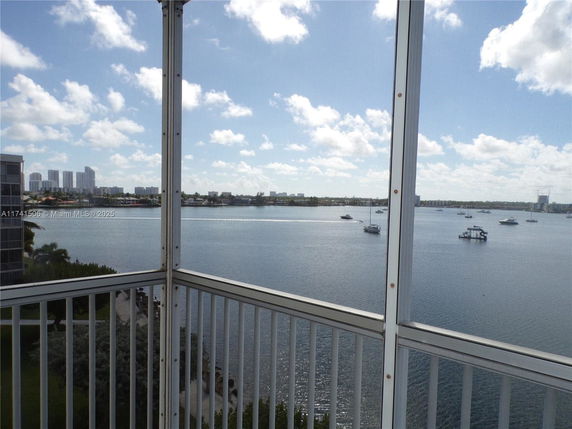 Panoramic view of water with boats and distant buildings from a balcony.