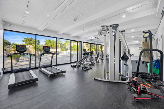 Indoor gym area with exercise equipment and large windows.
