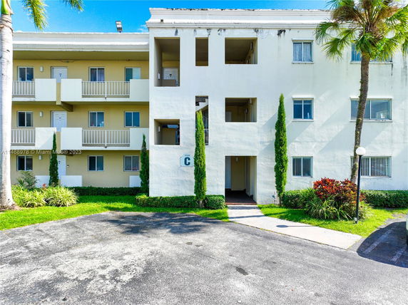Front view of a three-story apartment building with balconies.